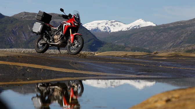 Africa Twin zaparkowana obok szybko płynącej rzeki w Norwegii