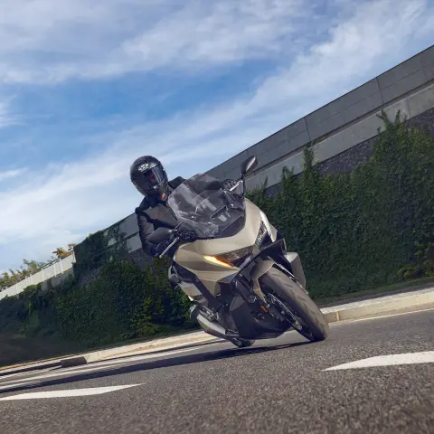 Model na motocyklu Forza 750 jadący po ulicy.